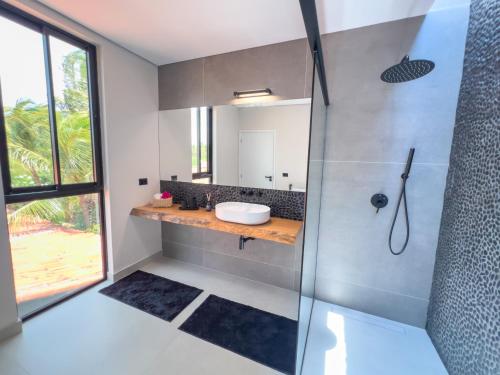 une salle de bain avec un lavabo et une douche dans l'établissement Vila Libelula, à São Miguel do Gostoso