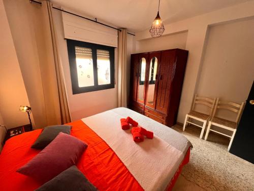 a bedroom with a bed with two red stuffed animals on it at La Casa del Musico 1 in Almería