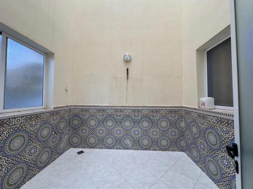 a bathroom with a tiled floor and a window at Appartement 135m new and furnished very good looking in Oujda