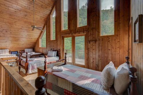 a bedroom with two beds in a room with windows at Hidden Creek Cabin in Fleetwood