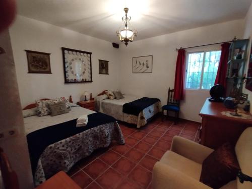 a hotel room with two beds and a chair at Loma Negra in Dúrcal