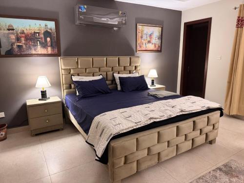 a bedroom with a large bed with a blue comforter at JW Apartments in Dargai
