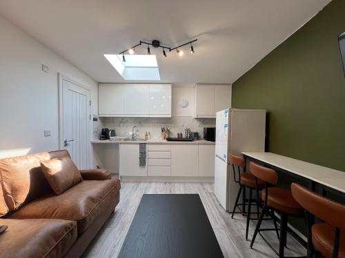 a living room with a couch and a kitchen at Little studio flat in Southgate
