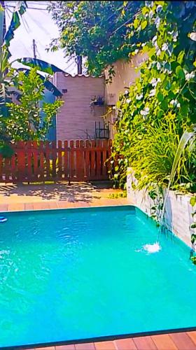 a large blue swimming pool with a wooden fence at Casa Andreia Borges in Aparecida de Goiania