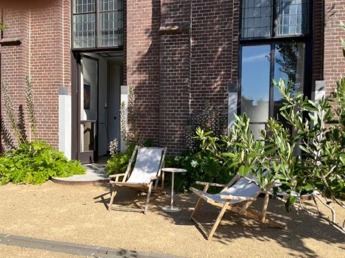 two chairs and a table in front of a building at De Hoffstee in Minnertsga