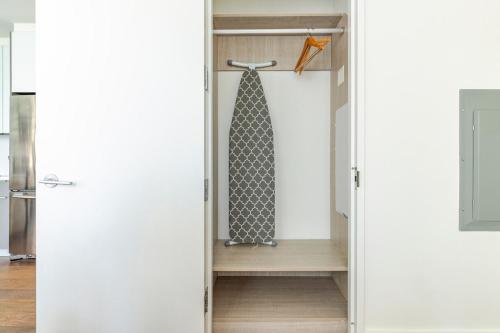 eine Krawatte, die in einem Schrank in der Küche hängt in der Unterkunft Blueground Long Island City rooftop nr Gantry Park NYC-1767 in Long Island City