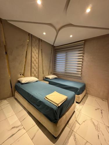 a bedroom with two beds and a window at roeya résidence in Nador