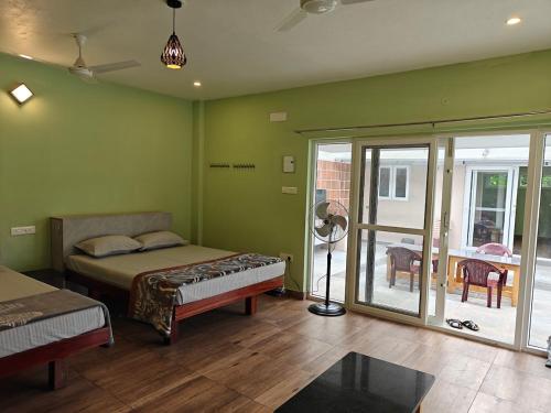 a bedroom with a bed and a sliding glass door at Maple Dreams Retreat- A Pool side Villa in Pondicherry