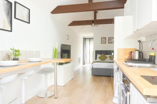 a kitchen with white walls and wooden countertops at Stylish Detached Studio, Banstead with off street Parking in Banstead