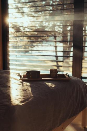 a bed in a room with a window with blinds at Domek Hawajka in Burlaki