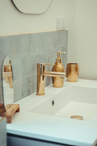 a bathroom sink with a soap dispenser on it at Domek Hawajka in Burlaki