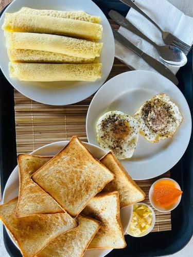 twee borden met toast en eieren op een dienblad bij Camellia Lodge Ella in Ella
