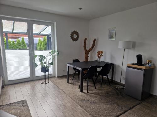 a dining room with a black table and chairs at Perle 110 in Bad Zwischenahn