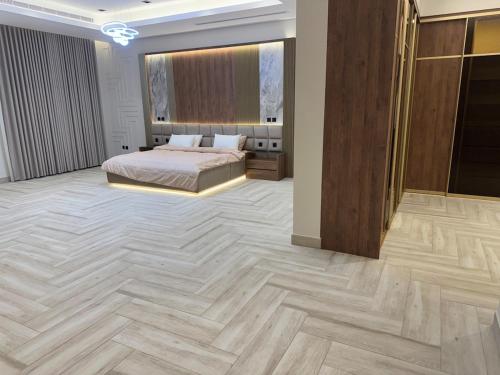 a bedroom with a bed and a wooden floor at Villa, 6BR with swimming pool next to Stars avenue in Jeddah