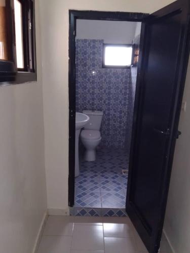 a bathroom with a toilet and a sink at Keur Vieux DIATTA in Ziguinchor