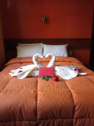 a bed with two swans made out of towels at Casa De Luz Hotel in Machu Picchu