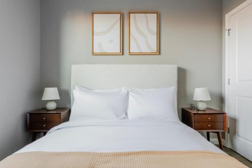 a bedroom with a large white bed with two lamps at Blueground Central Square rooftop nr Harvard BOS-1258 in Cambridge