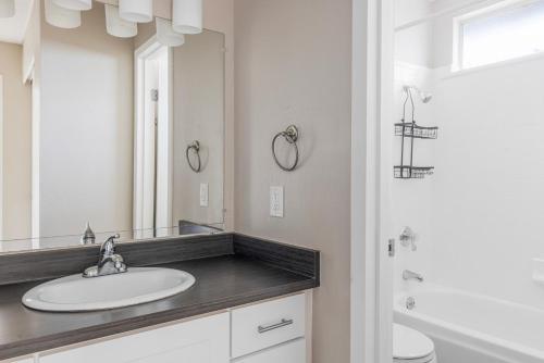 a bathroom with a sink and a mirror at Blueground West Valley pool nr Memorial Park SFO-2051 in Rancho Rinconada