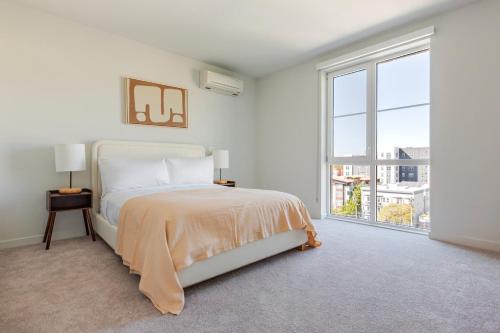 Un dormitorio blanco con una cama y una ventana grande. en Blueground Downtown Berkeley rooftop nr UC Berkeley SFO-1984, en Berkeley