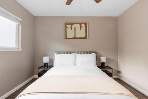 a bedroom with a large white bed with two lamps at Blueground Downtown pool nr Civic Center SFO-2069 in Hayward Park