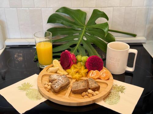 a plate of bread and fruit on a table with a glass of orange juice at Ocean-Facing Maui B&B Room - Breakfast, BBQ & AC in Lahaina