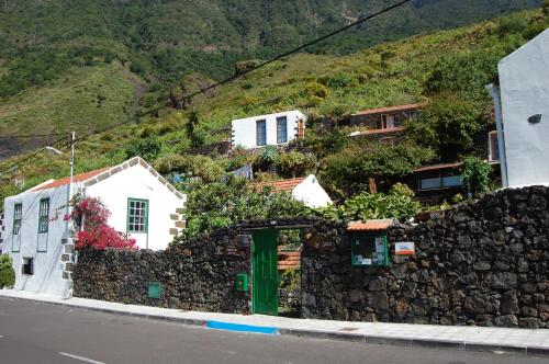 ein Haus auf einem Hügel mit einer Steinmauer in der Unterkunft El Sitio in Frontera