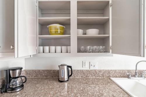 encimera de cocina con armarios blancos y fregadero en Blueground Downtown Austin pool nr Congress Ave ATX-340, en Austin