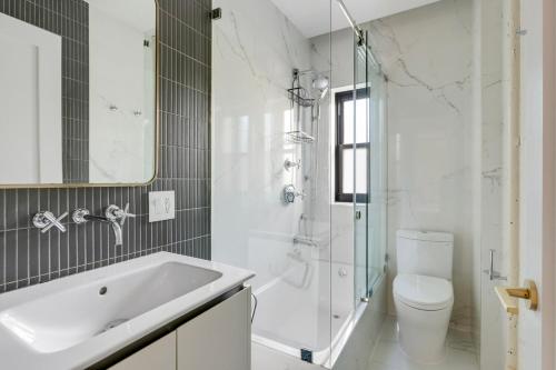 a white bathroom with a sink and a toilet at Blueground Brooklyn Heights view nr Brooklyn Bridge NYC-1987 in Brooklyn