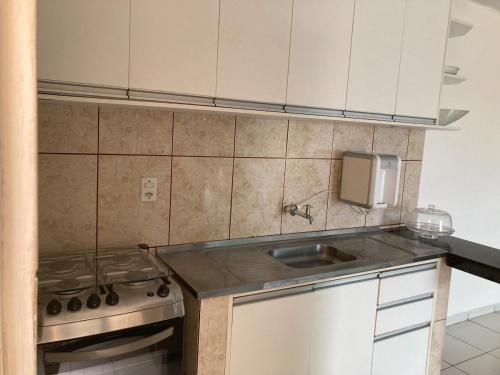 a small kitchen with a sink and a stove at Studio Shine - Apartamento inteiro para COP in Belém