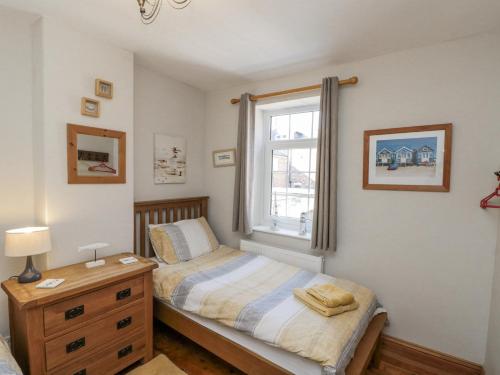 una piccola camera da letto con un letto e una finestra di Chapel Cottage a Filey