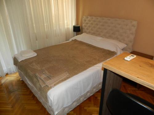 a bedroom with a large bed with a wooden table at Alesandro in Jagodina
