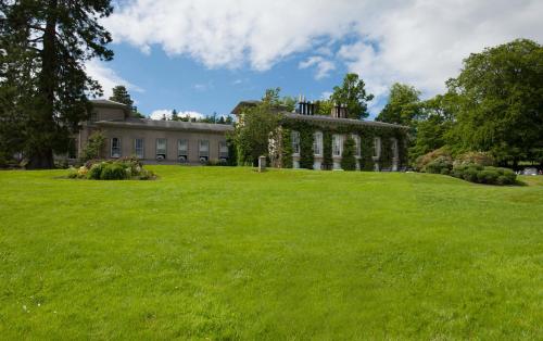 a large grassy field in front of a building at Thainstone House in Inverurie