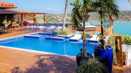 a pool with a palm tree in a resort at Mar Búzios inn in Búzios