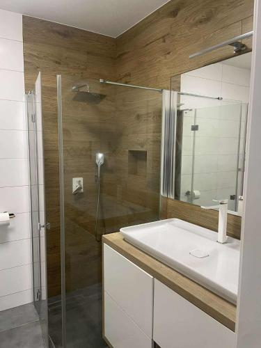 a bathroom with a shower and a white sink at APATRAMET Królowej Jadwigi 12A in Giżycko
