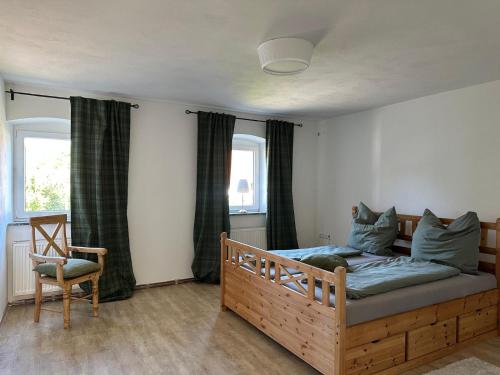 a bedroom with a wooden bed and a chair at Maison de Chasse Karlsbrunn in Großrosseln