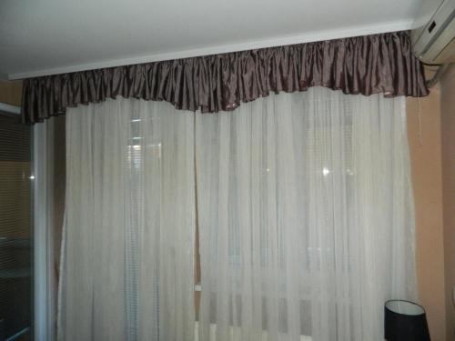 a window with white curtains in a room at Alesandro in Jagodina