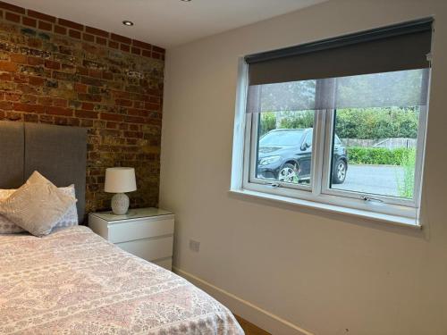 a bedroom with a bed and a window with a car outside at Stunning Studio1, Banstead with free off st parking in Banstead