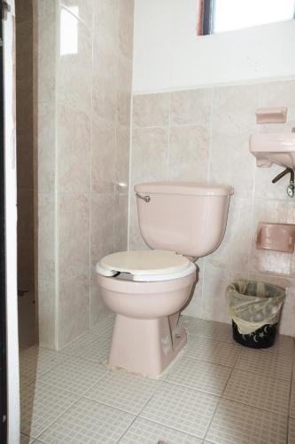 a bathroom with a white toilet and a sink at Arena Surf Hotel, Puerto Escondido in Puerto Escondido