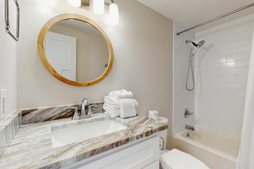 un bagno bianco con lavandino e specchio di Coral Sunset a Fort Morgan