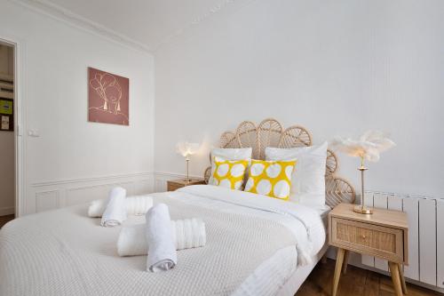 Un dormitorio blanco con dos camas con toallas. en 3P Cosy proche Paris La Défense Fondation LV, en Suresnes