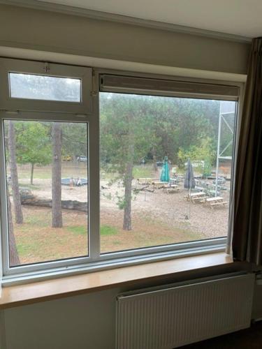 una ventana en una habitación con vista a un parque en Boslust, en Bergen op Zoom