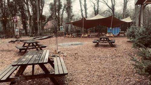 Dos mesas de picnic y una tienda de campaña en un parque en Boslust, en Bergen op Zoom
