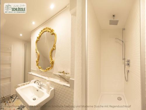 ein Badezimmer mit Waschbecken und Spiegel in der Unterkunft Schloss Seeburg in Seeburg