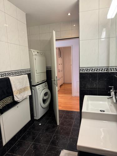 a bathroom with a washing machine and a sink at City Apartment in Opfikon