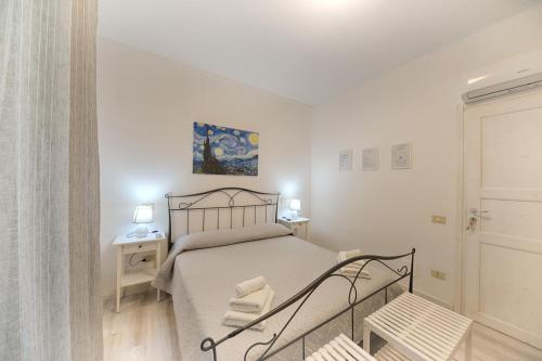 Un dormitorio con una cama en una habitación blanca. en Margherita Guest House, en Olbia