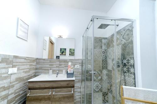 un baño con ducha y lavabo en Margherita Guest House, en Olbia