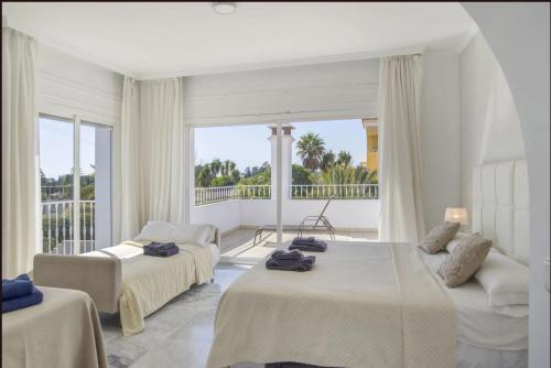 ein Hotelzimmer mit zwei Betten und Balkon in der Unterkunft Elegant Villa Retreat with Lush Gardens in Marbella
