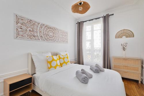 シュレーヌにある3P Cocooning prés Paris La Défense Champs Élyséesのタオルが敷かれた白いベッドのある寝室