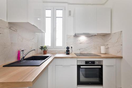 シュレーヌにある3P Cocooning prés Paris La Défense Champs Élyséesのシンクとコンロのある白いキッチン