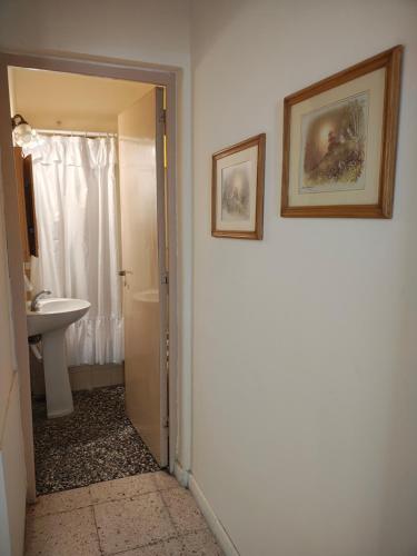 a bathroom with a toilet and a sink and a mirror at Departamento Peña in Carhué